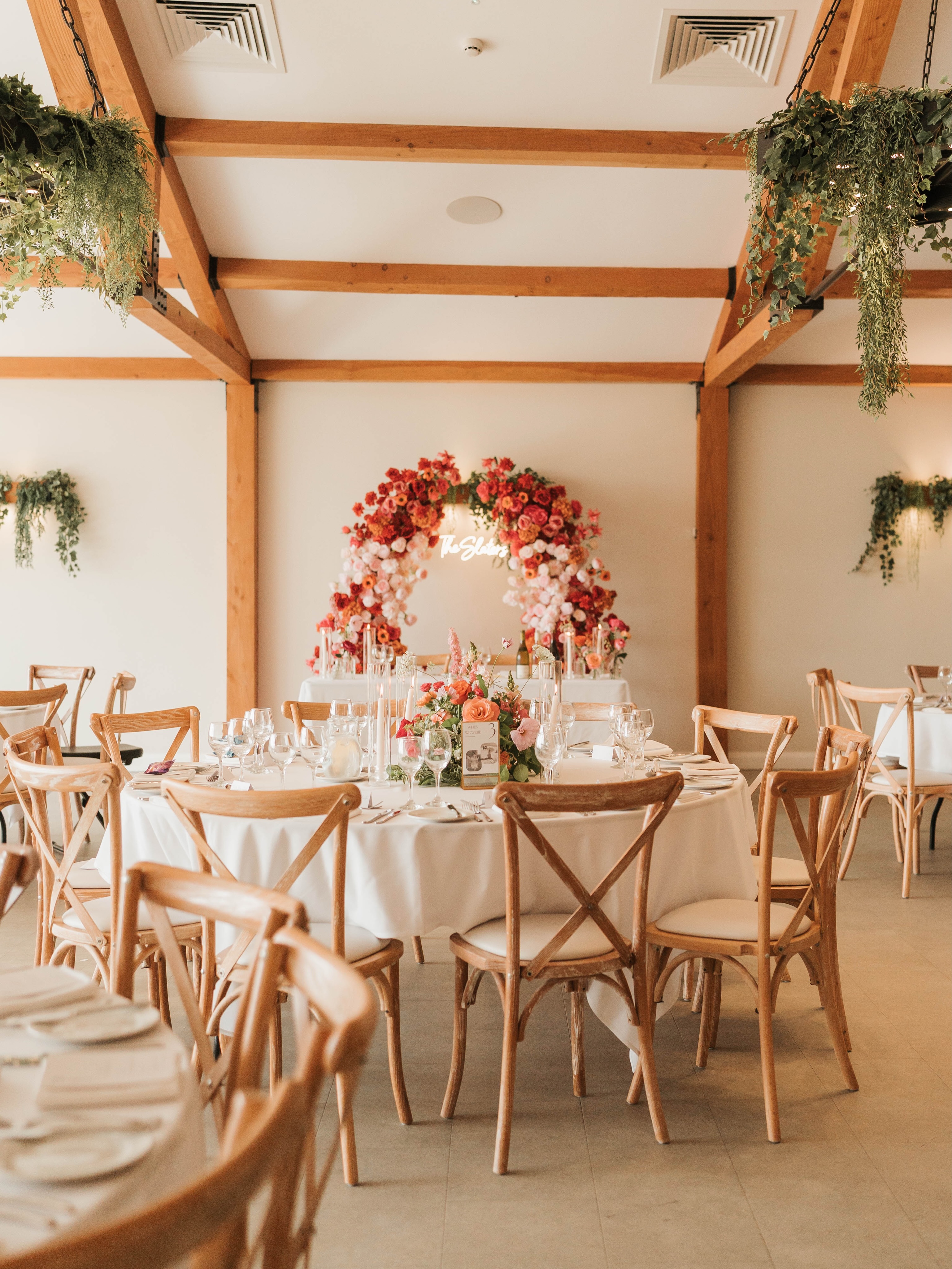🌸 Before and after the big entrance… a backdrop to memories that’ll last forever 🧡
.
Perfectly captured by @photographybyamielouise
.
#floralarch #flowerpillars #sweethearttable #weddingflowerinspo #pinkandorange