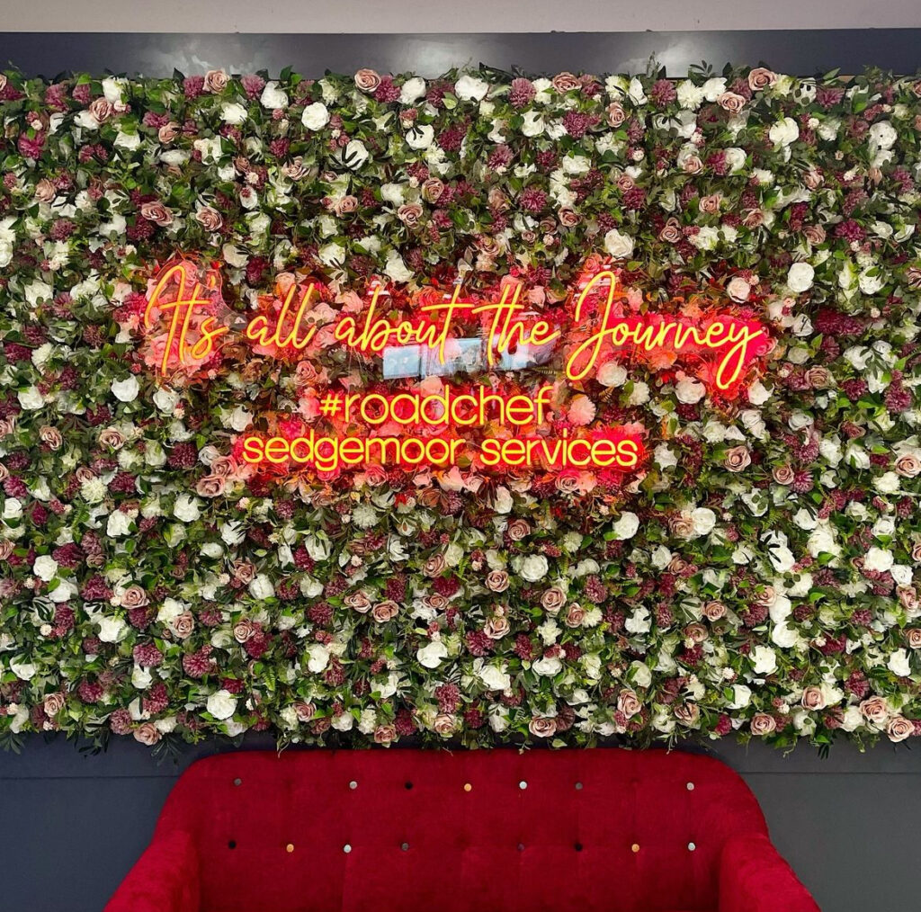 flower wall with neon sign